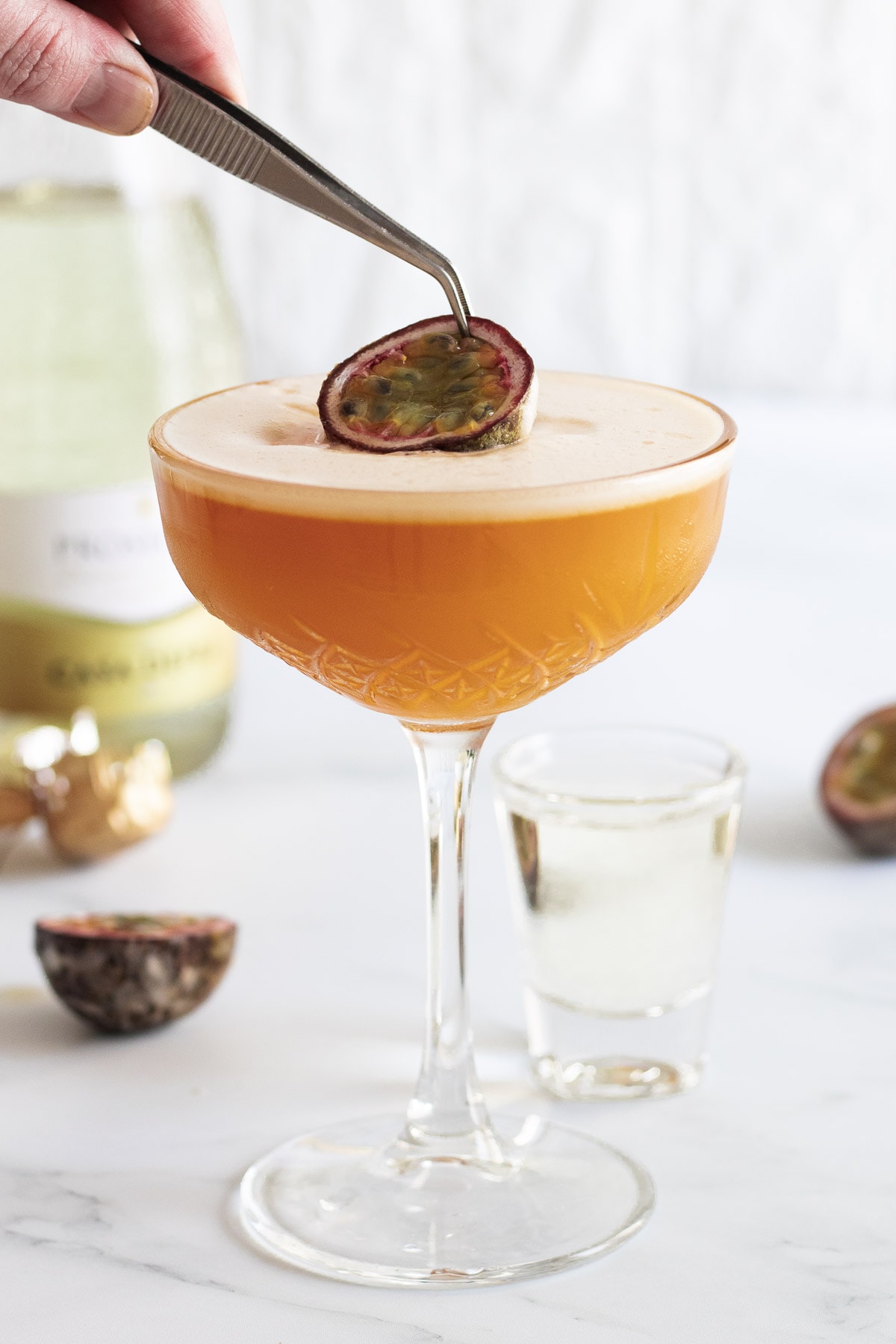 Passionfruit being placed on a pornstar martini