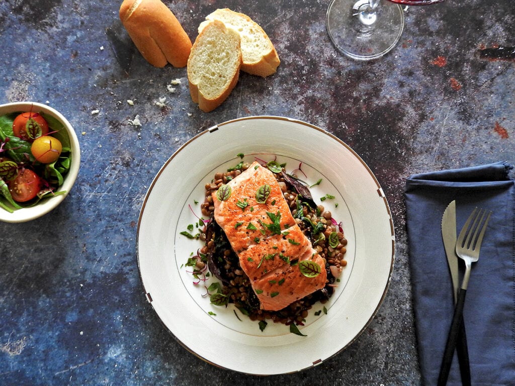 Pan seared salmon with lentils on a plate