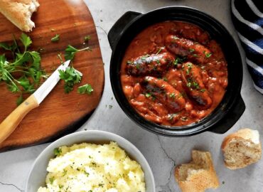 Slow Cooker Sausage Casserole with Side of Mash and Chopped Parsley