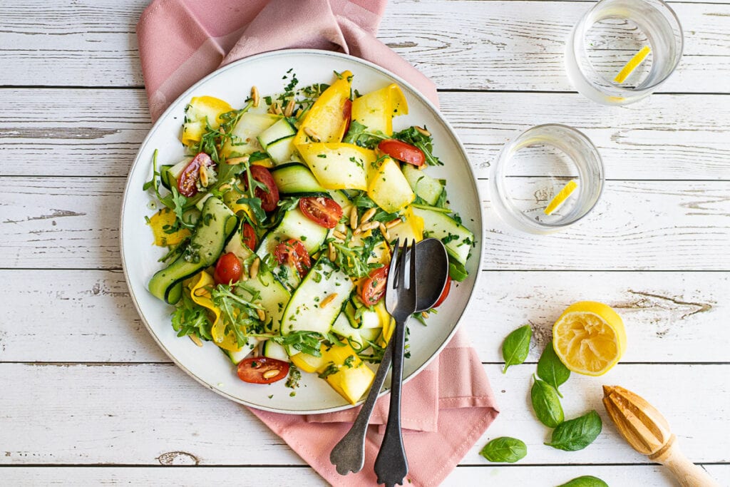 Courgette salad on a plate with a juiced lemon