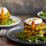 Courgette and Sweetcorn Fritters on a plate with rocket and poached egg
