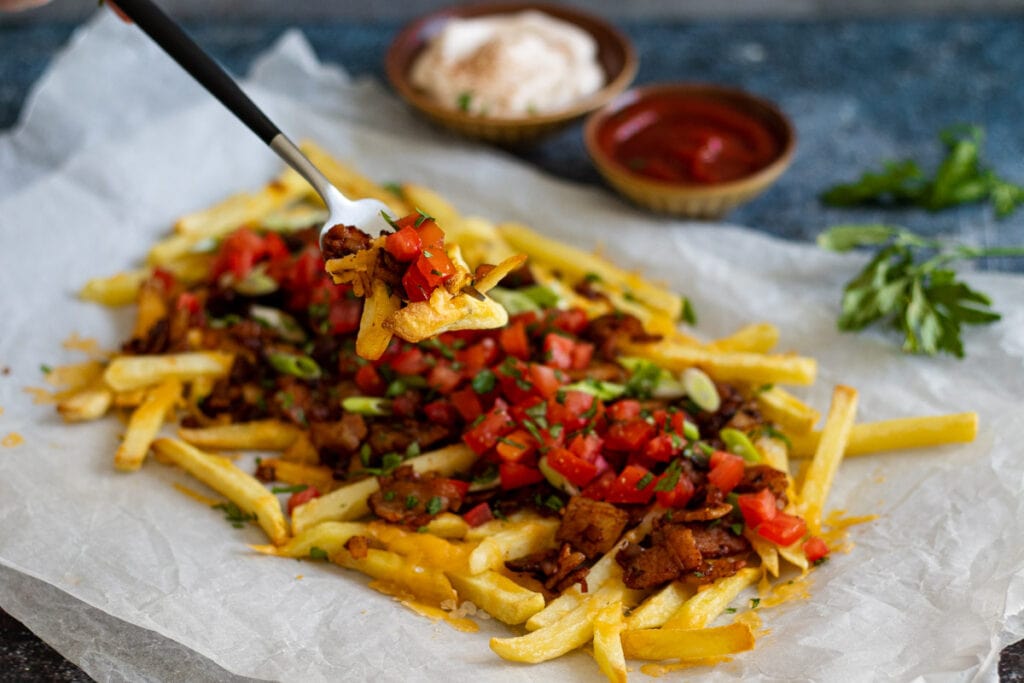 Dirty fries being picked up on a fork