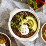 Slow cooker chilli con carne in a bowl with avocado