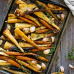 Carrots and parsnips roasted on a tray with honey