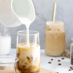 Milk being poured into an iced latte