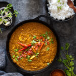 Chicken dhansak in a pan with rice and coriander