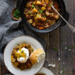 Slow cooker corned beef hash served on to plates with poached egg