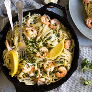 Creamy prawn linguine with lemon slices in a pan